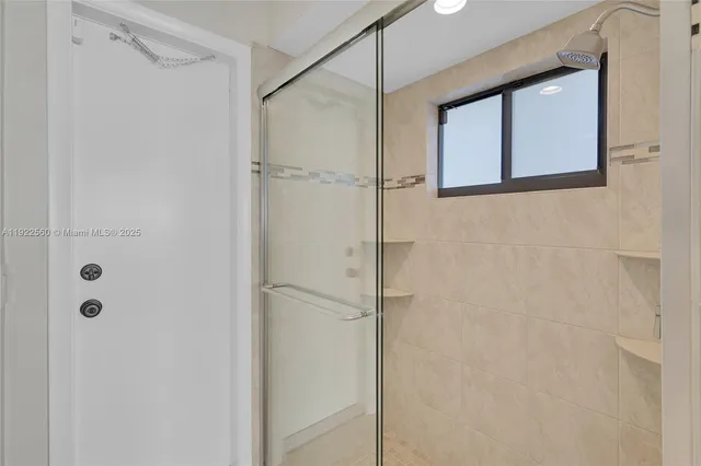 a bathroom with a shower and a glass door