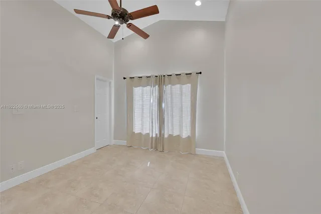an empty room with a ceiling fan and window