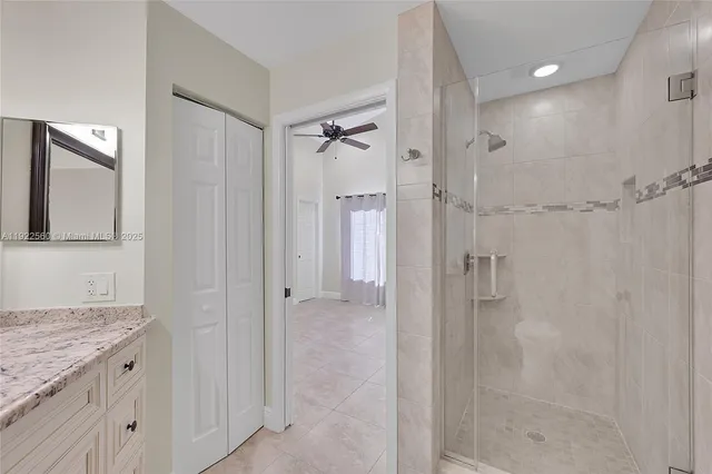 a bathroom with a granite countertop sink mirror and shower