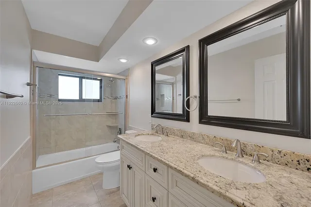 a bathroom with a granite countertop sink a toilet and bathtub