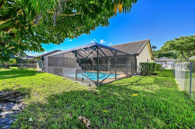 a view of a house with backyard and a tree