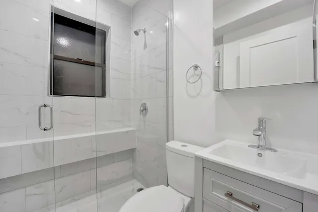 a bathroom with a sink a toilet and shower