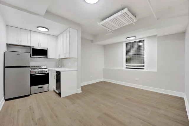 a kitchen with stainless steel appliances a stove top oven a sink and a refrigerator