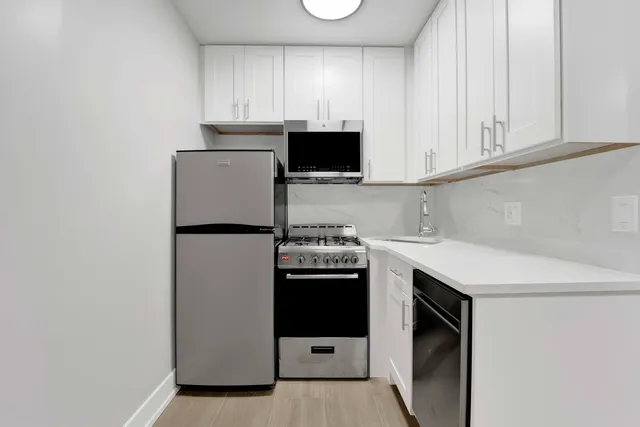 a kitchen with stainless steel appliances granite countertop a refrigerator and a stove top oven