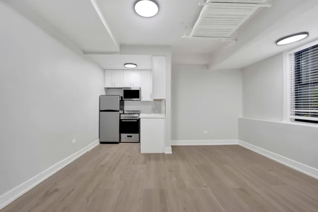 a view of a kitchen with a sink stove refrigerator and window