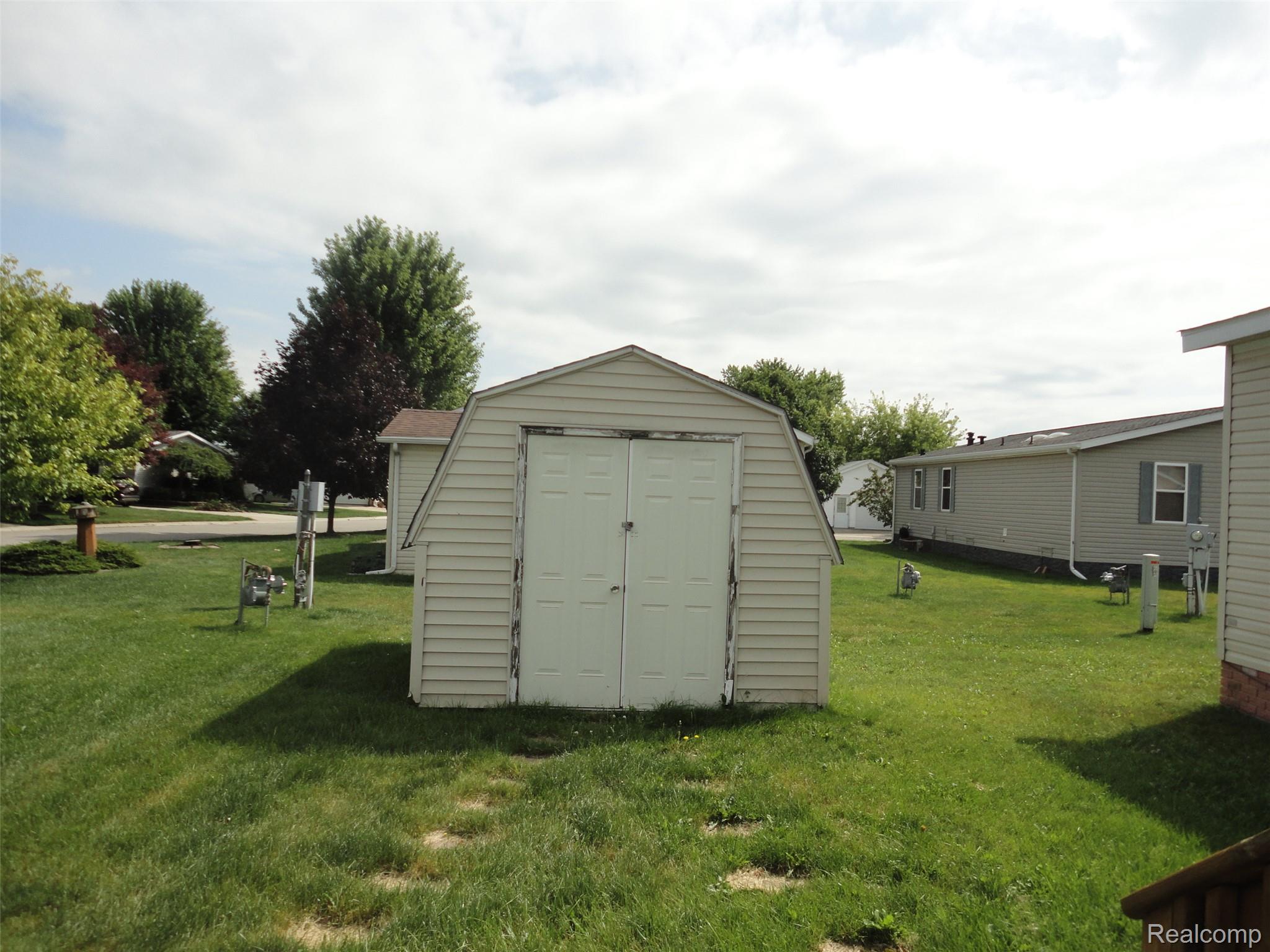 3954 Ryans Ridge Monroe, MI 48161 - Photo 28 of 28 Gable-roofed storage shed with double white doors, set on a grass lawn