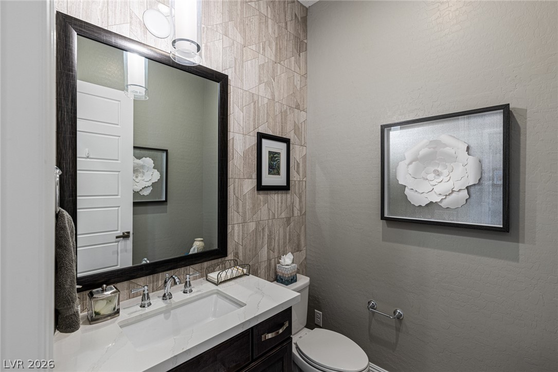 10118 Copper Edge Road Las Vegas, NV 89148 - Photo 29 of 48 A striking powder room features a sophisticated vanity with ample counter space and a prominent mirror.