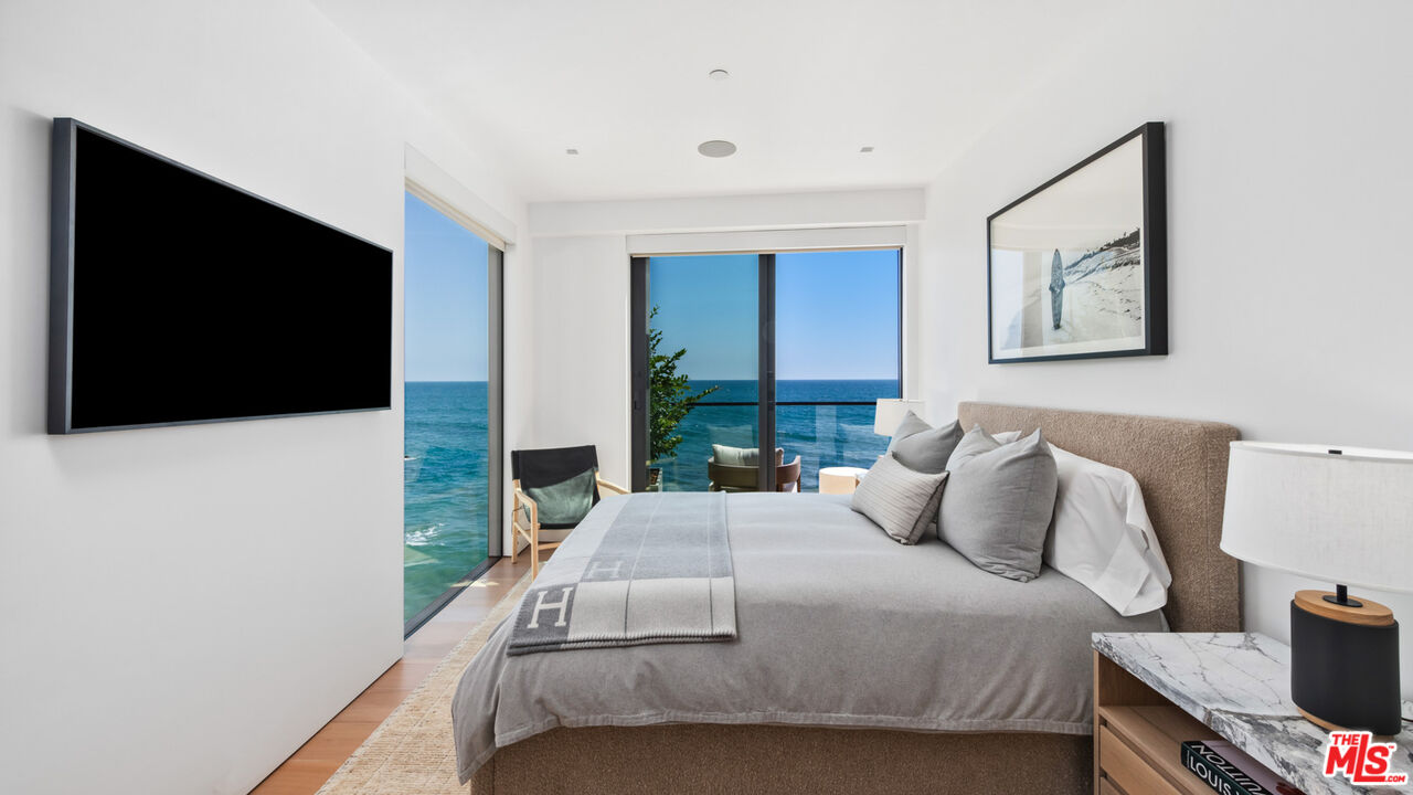 18954 Pacific Coast Highway Malibu, CA 90265 - Photo 34 of 70 a bedroom with a bed and a flat screen tv