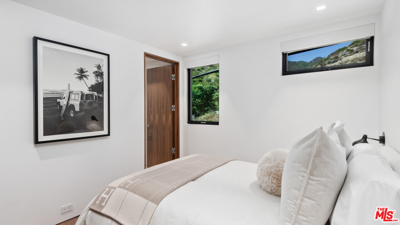 18954 Pacific Coast Highway Malibu, CA 90265 - Photo 36 of 70 a bedroom with a bed and a painting on the wall