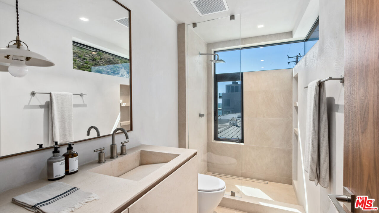 18954 Pacific Coast Highway Malibu, CA 90265 - Photo 37 of 70 a bathroom with a double vanity sink a toilet and shower