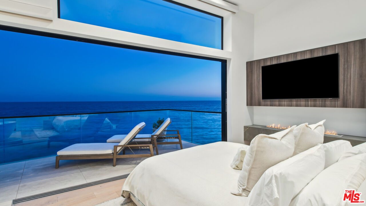 18954 Pacific Coast Highway Malibu, CA 90265 - Photo 64 of 70 a bedroom with a bed and a flat screen tv