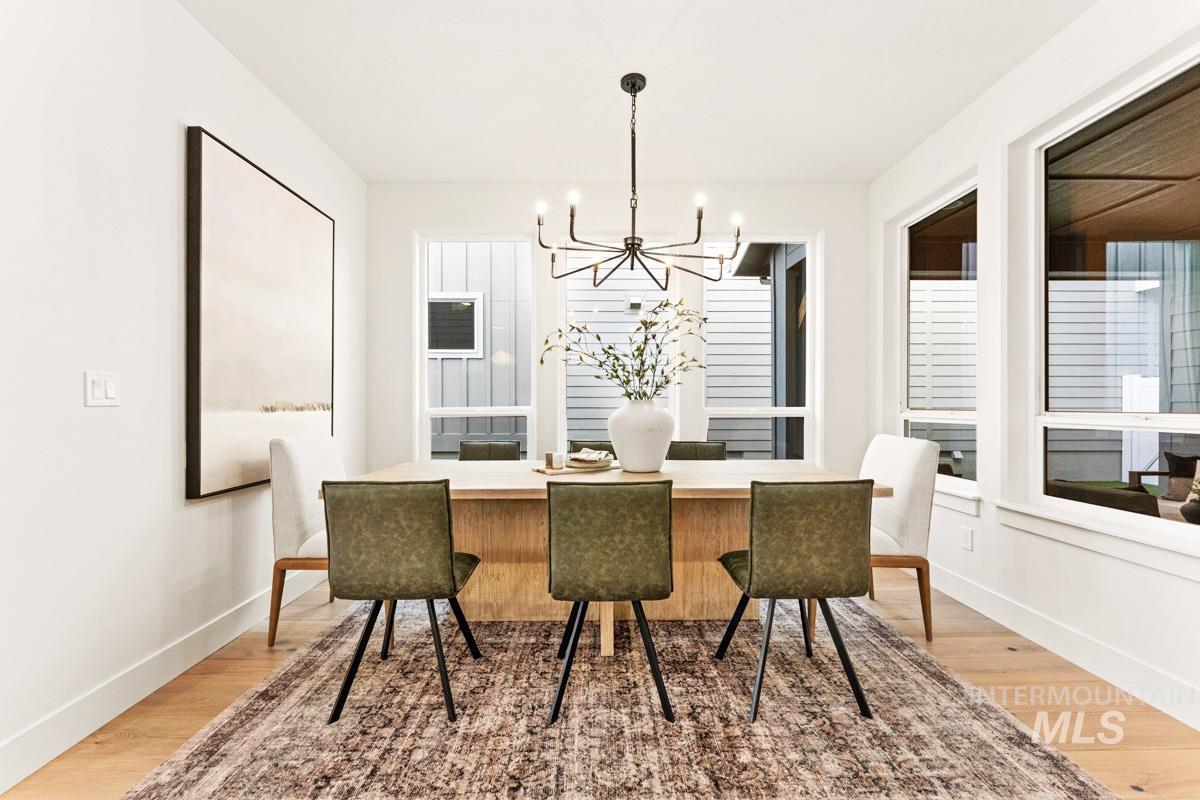13338 North Spring Creek Way Boise, ID 83714 - Photo 10 of 46 Dining area featuring light wood-finish flooring, white baseboards, and bright white walls