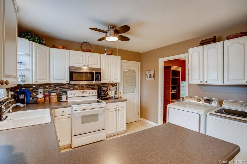 4921 Cheviot Road Charlotte, NC 28269 - Photo 13 of 28 a kitchen with stainless steel appliances white cabinets and a refrigerator