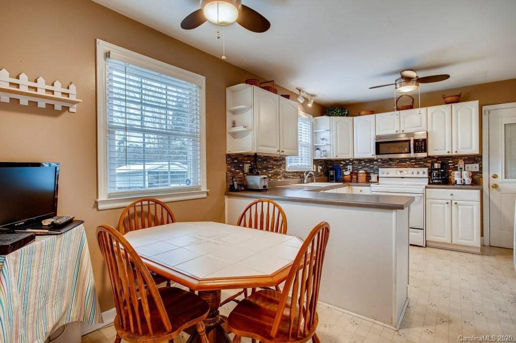 4921 Cheviot Road Charlotte, NC 28269 - Photo 14 of 28 a kitchen with stainless steel appliances granite countertop a sink a microwave refrigerator and a stove