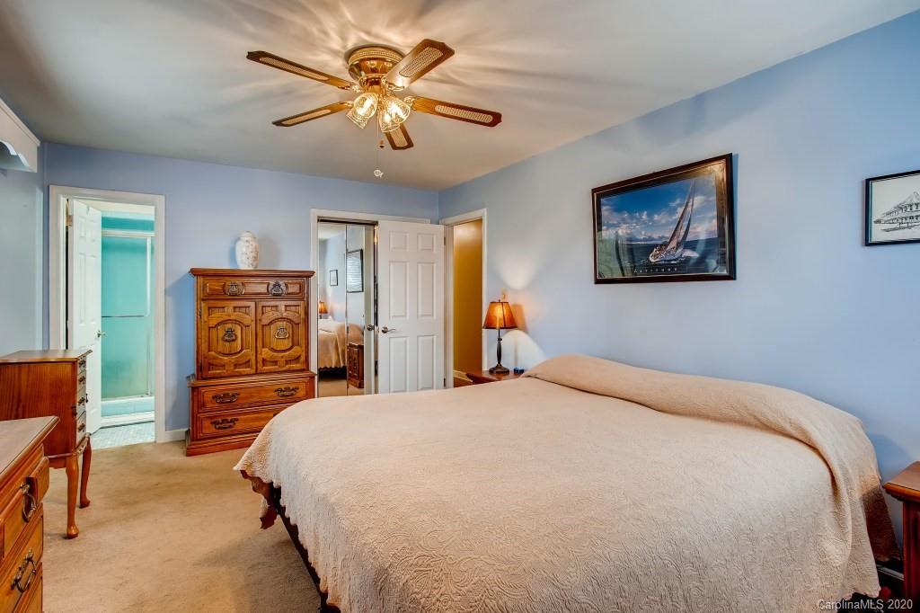 4921 Cheviot Road Charlotte, NC 28269 - Photo 17 of 28 a bedroom with a bed and a chandelier