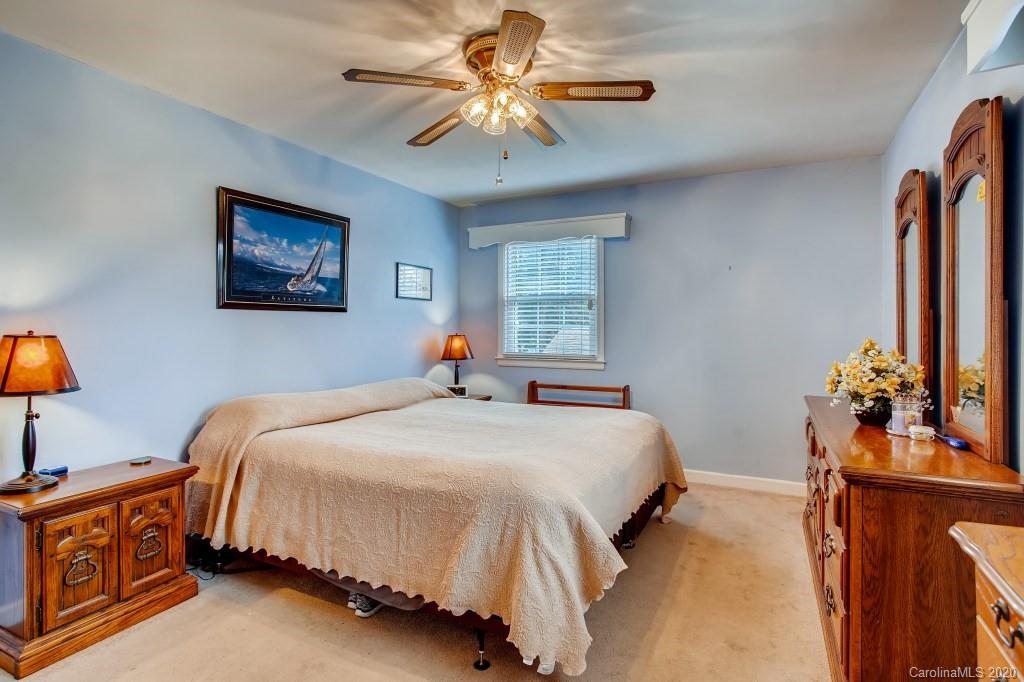 4921 Cheviot Road Charlotte, NC 28269 - Photo 18 of 28 a bedroom with a bed and a chandelier