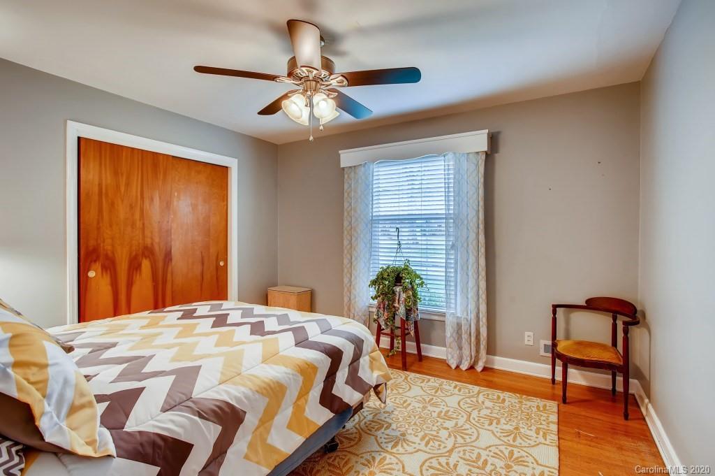4921 Cheviot Road Charlotte, NC 28269 - Photo 20 of 28 a bedroom with a bed and a chandelier