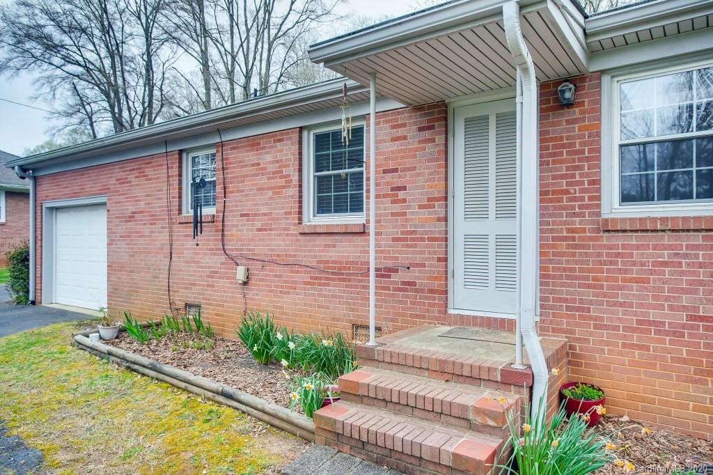 4921 Cheviot Road Charlotte, NC 28269 - Photo 23 of 28 a front view of a house with a yard and potted plants