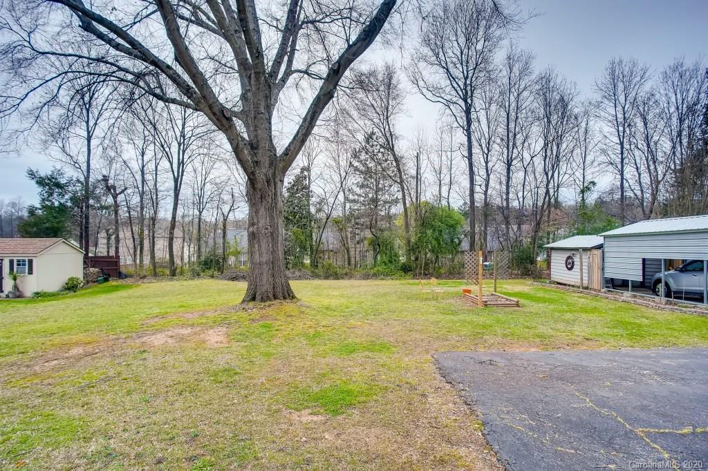 4921 Cheviot Road Charlotte, NC 28269 - Photo 27 of 28 a view of a house with a big yard and large trees