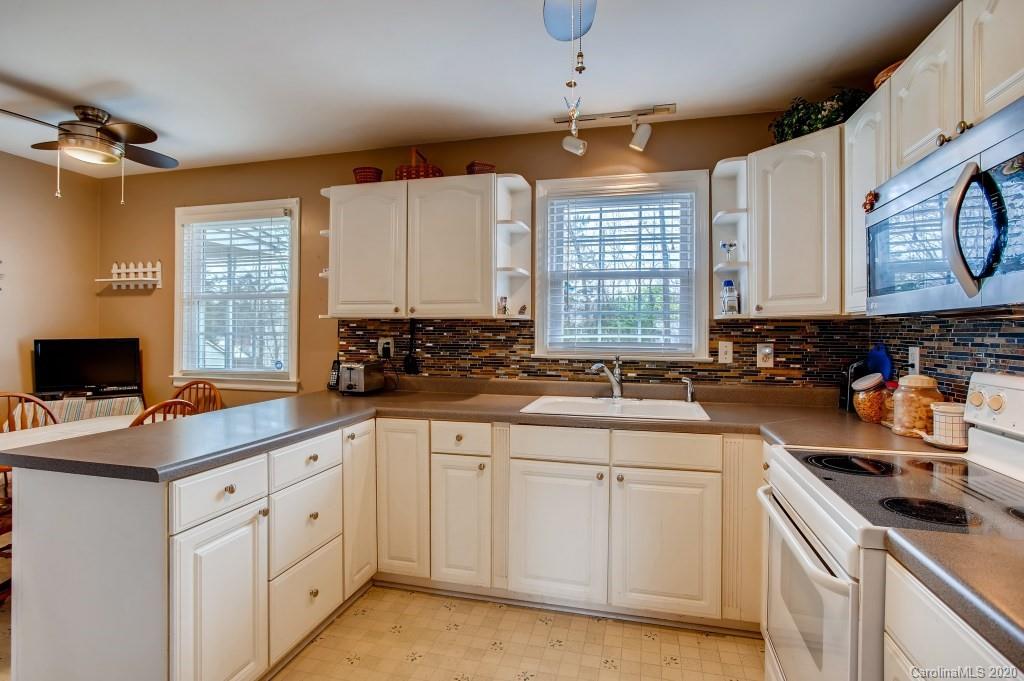 4921 Cheviot Road Charlotte, NC 28269 - Photo 10 of 28 a kitchen with white cabinets and white appliances