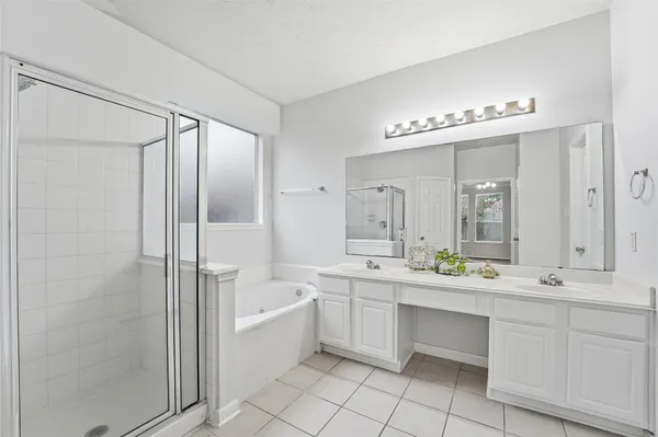 a large bathroom with a double vanity sink a mirror and a bathtub