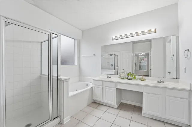 a large bathroom with a double vanity sink a mirror and a bathtub