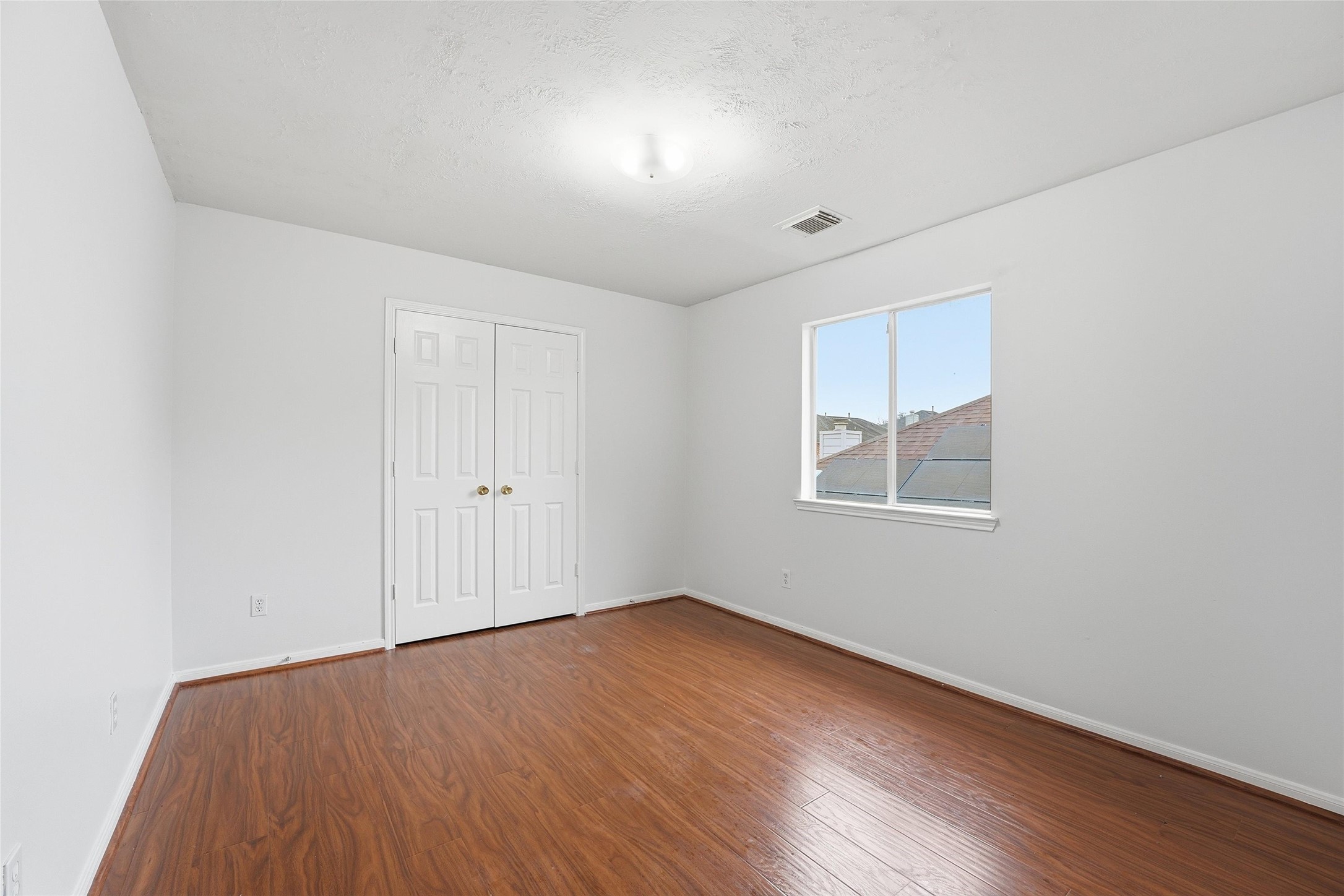 8522 Chickamauga Lane Houston, TX 77083 - Photo 20 of 33 an empty room with wooden floor and windows