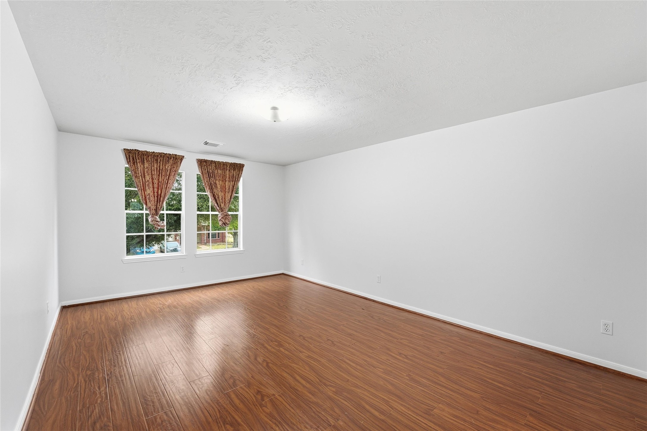 8522 Chickamauga Lane Houston, TX 77083 - Photo 22 of 33 an empty room with wooden floor and windows