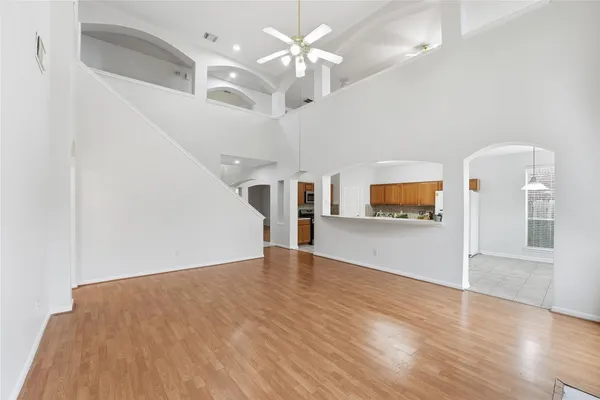 wooden floor in an empty room with a chandelier fan