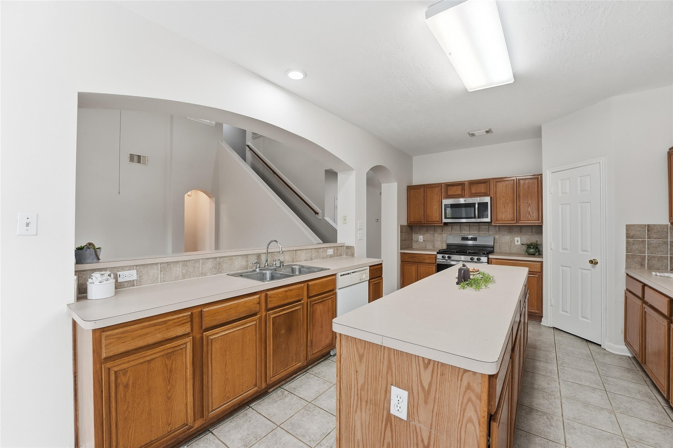 8522 Chickamauga Lane Houston, TX 77083 - Photo 9 of 33 a large kitchen with kitchen island a sink stainless steel appliances and cabinets