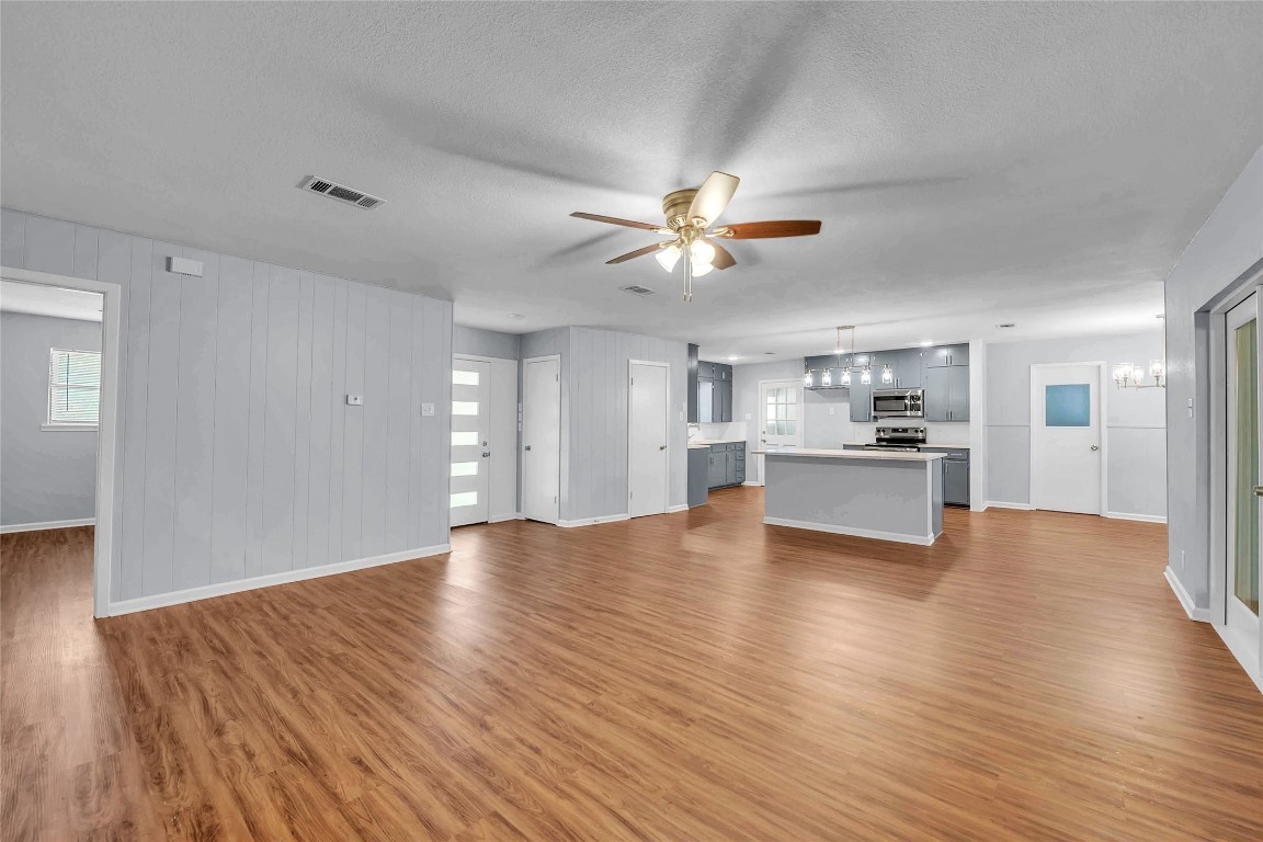 310 Hruskaville Road Temple, TX 76501 - Photo 10 of 21 Unfurnished living room featuring a chandelier, light wood-style floors, a textured ceiling, and ceiling fan