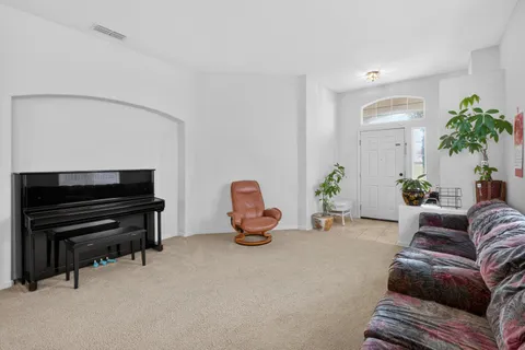 a living room with furniture and a piano