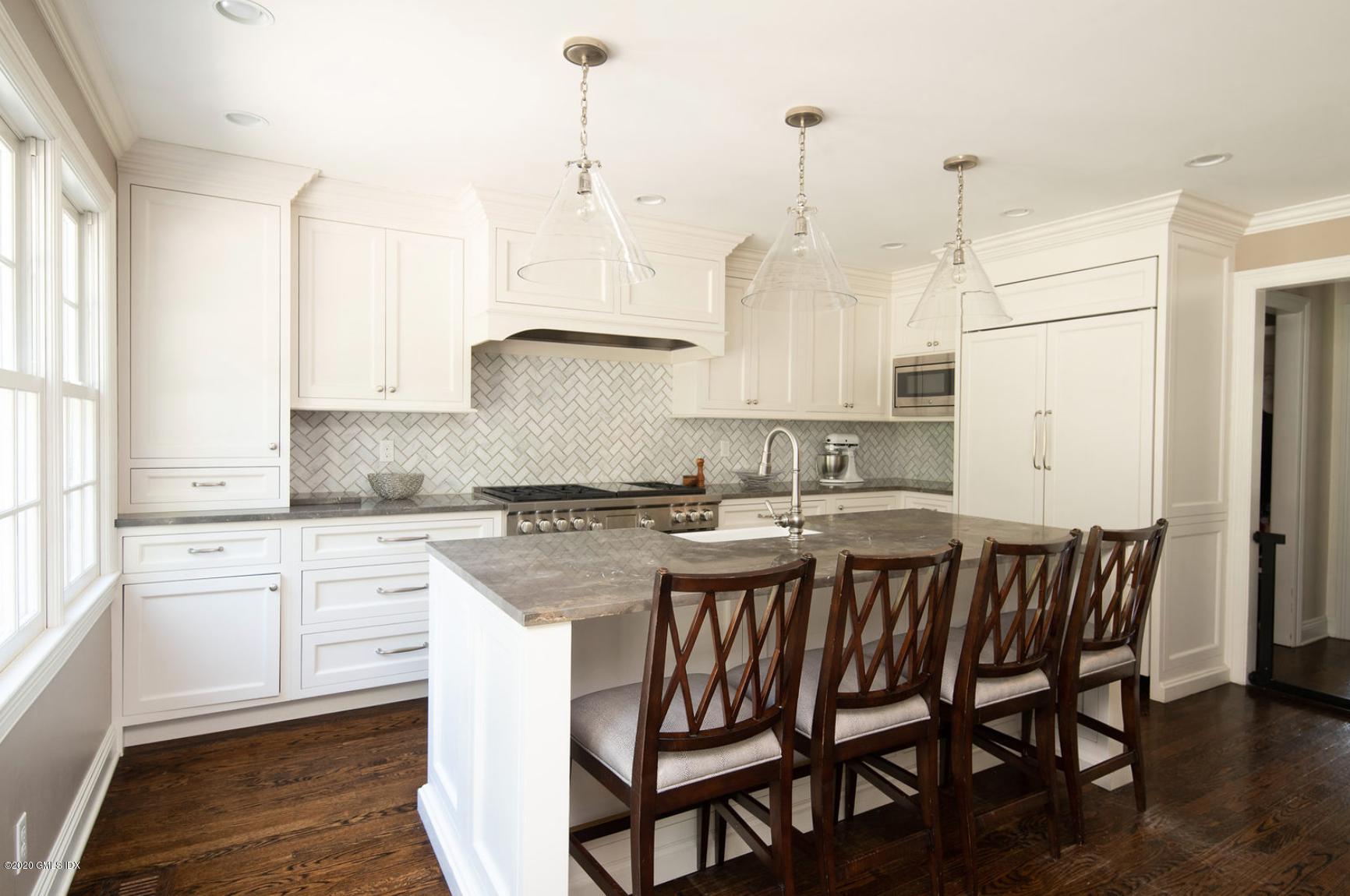 88 Birch Lane Greenwich, CT 06830 - Photo 15 of 33 a kitchen with a stove a sink and white cabinets with wooden floor