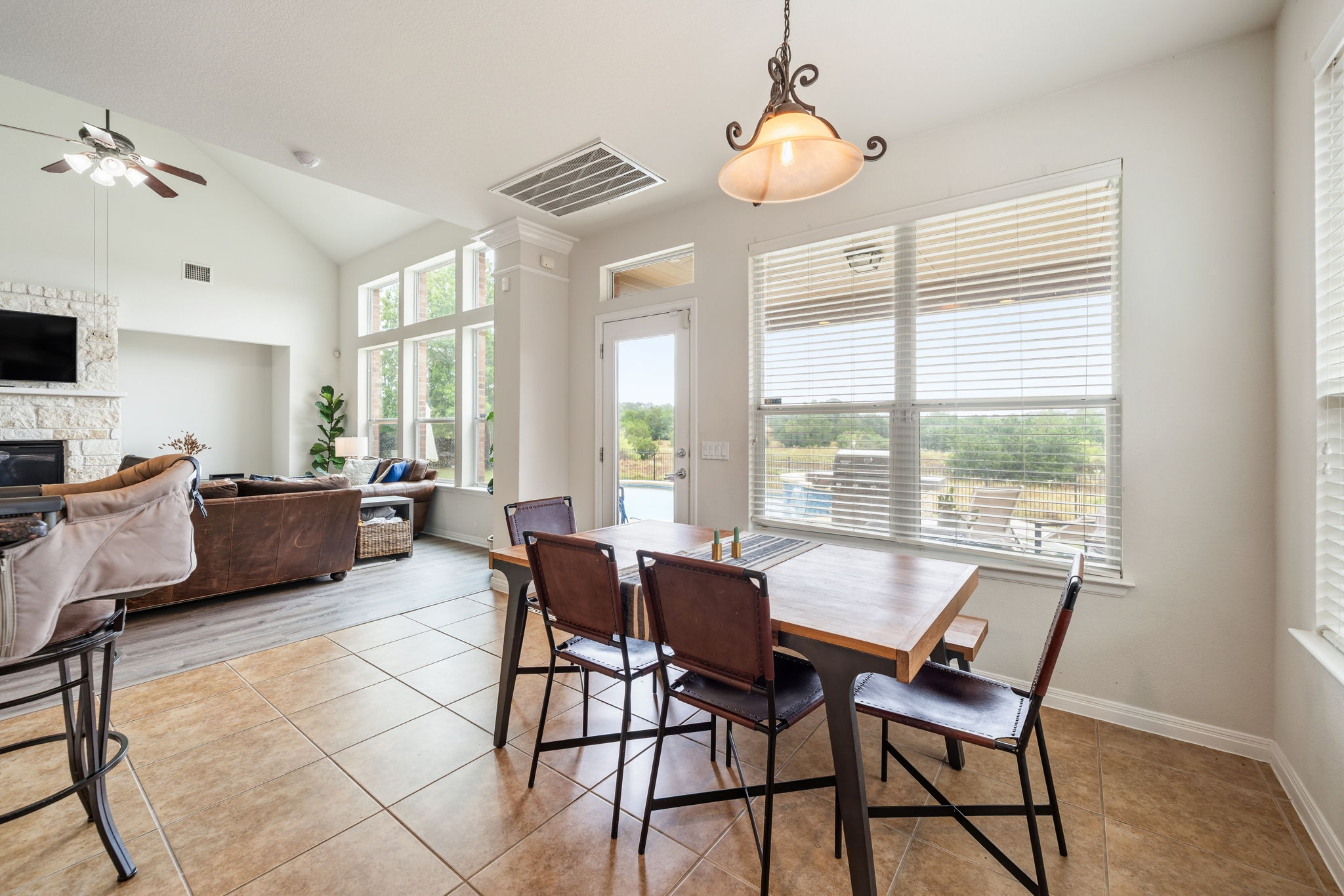 1581 Grassy Field Road Austin, TX 78737 - Photo 10 of 37 Natural light floods the tile-floored dining area through large windows looking out to the yard.