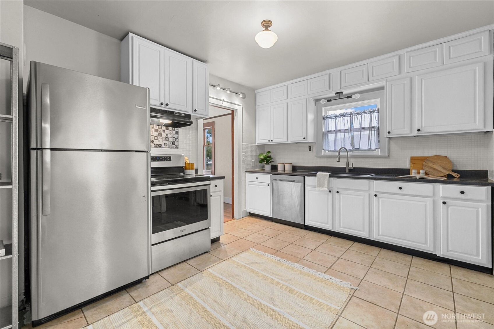 1211 North 3rd Street Renton, WA 98057 - Photo 10 of 40 a kitchen with stainless steel appliances a refrigerator sink and cabinets