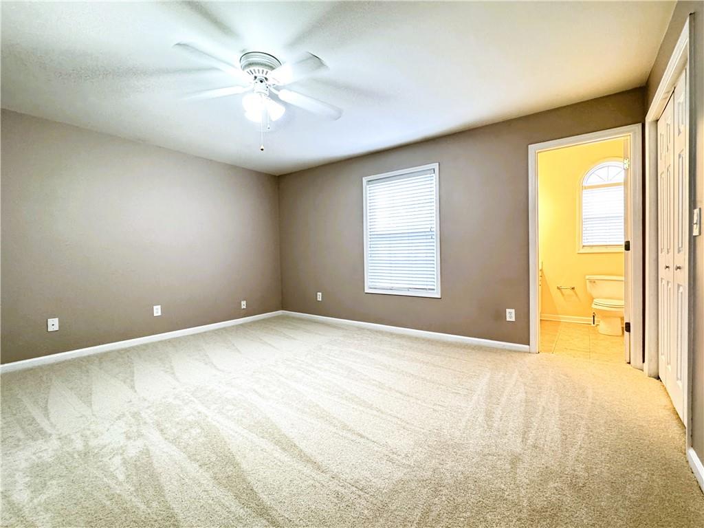 112 Summer Place Northwest Norcross, GA 30071 - Photo 16 of 24 an empty room with a chandelier fan and windows