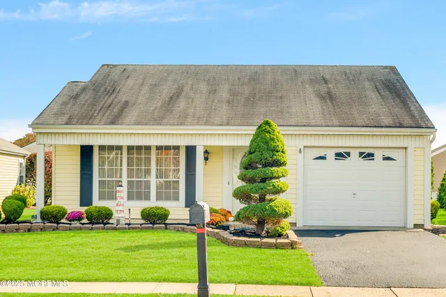 a front view of a house with a garden and plants