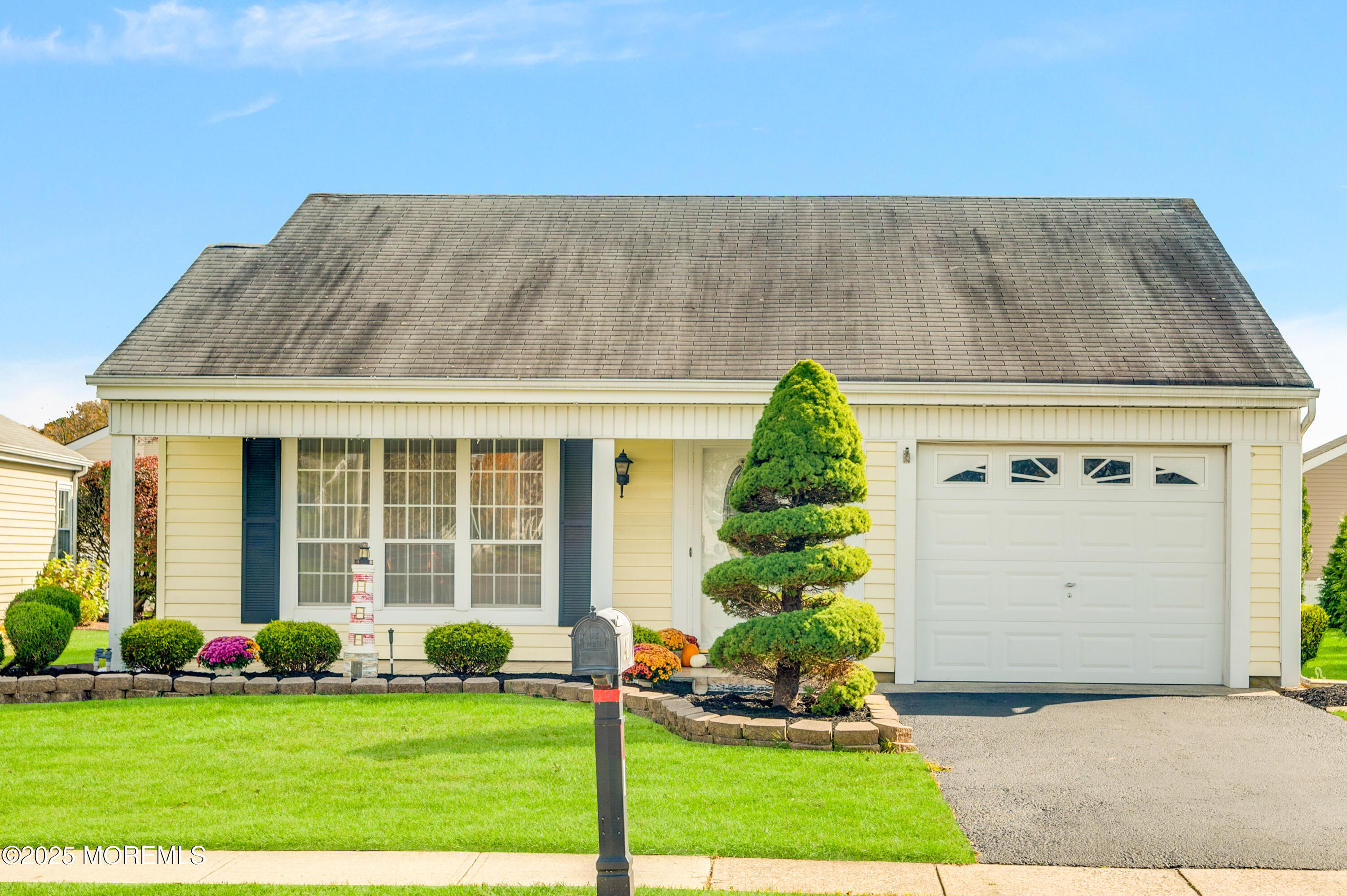 a front view of a house with a garden and plants