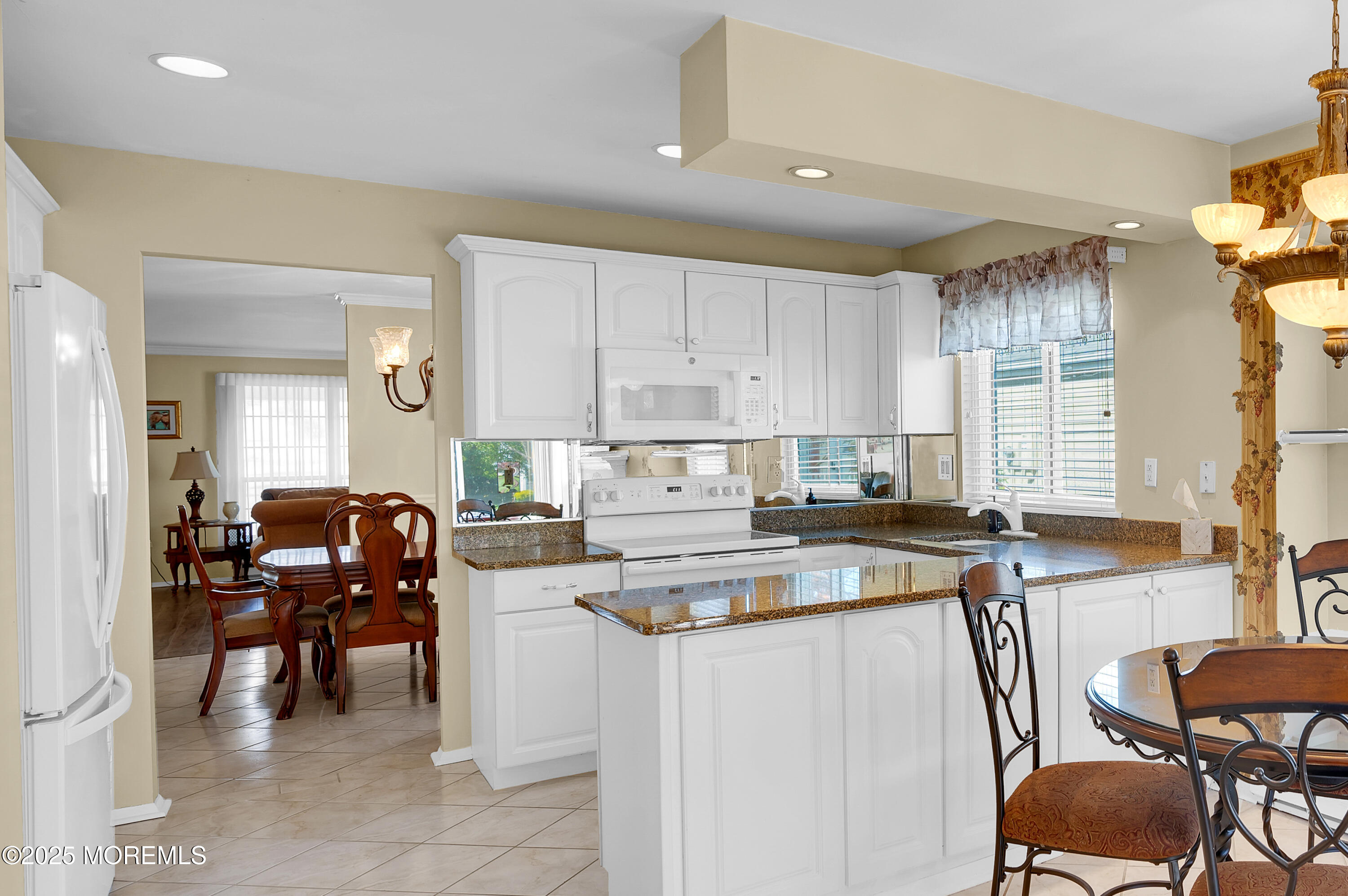 41 Red Hill Road Manchester Township, NJ 08759 - Photo 26 of 39 a kitchen with a stove a sink a dining table and chairs