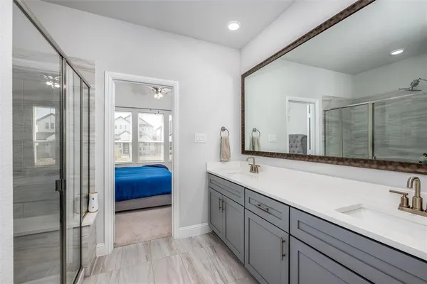 a spacious bathroom with a shower sink and mirror