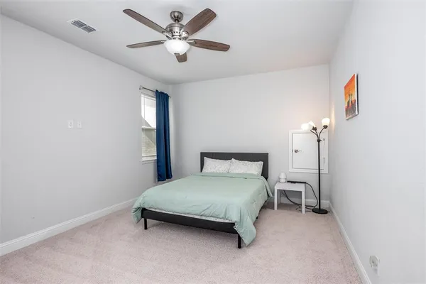 a view of a room with a ceiling fan and window