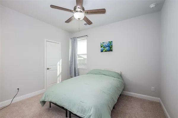 a view of a bedroom with a bed and a chandelier fan