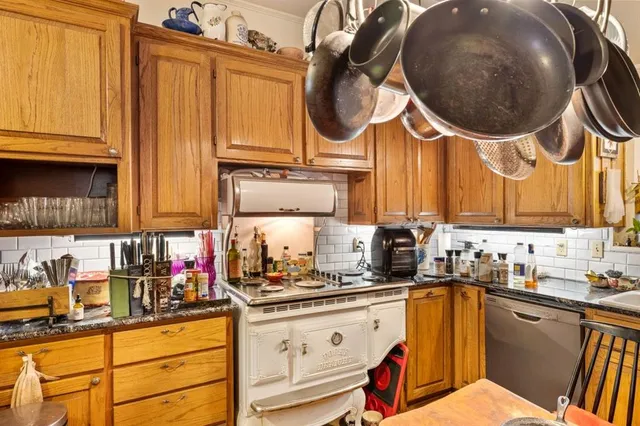 a kitchen with stainless steel appliances granite countertop a sink a stove and a wooden cabinets
