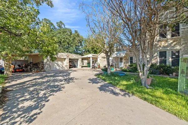 a front view of a house with a yard and tree s