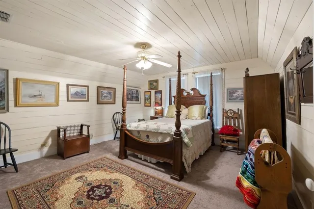 a spacious bedroom with a bed a couch and dresser