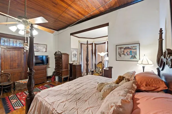 a bedroom with a bed a dresser and book shelf