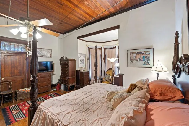 a bedroom with a bed a dresser and book shelf