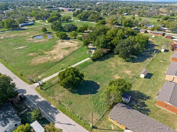 an aerial view of residential houses with outdoor space and trees