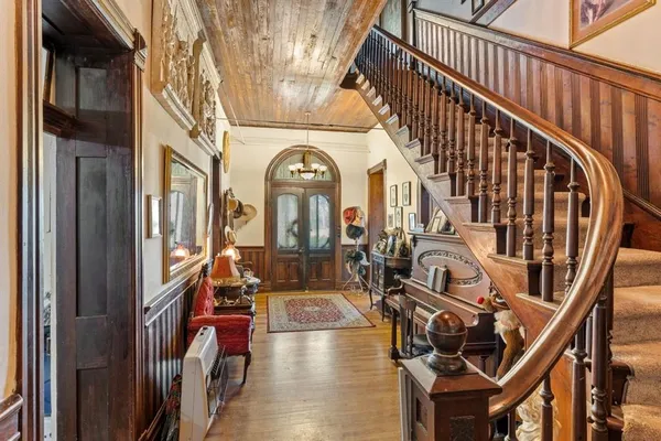 a view of an entryway with wooden floor and livingroom
