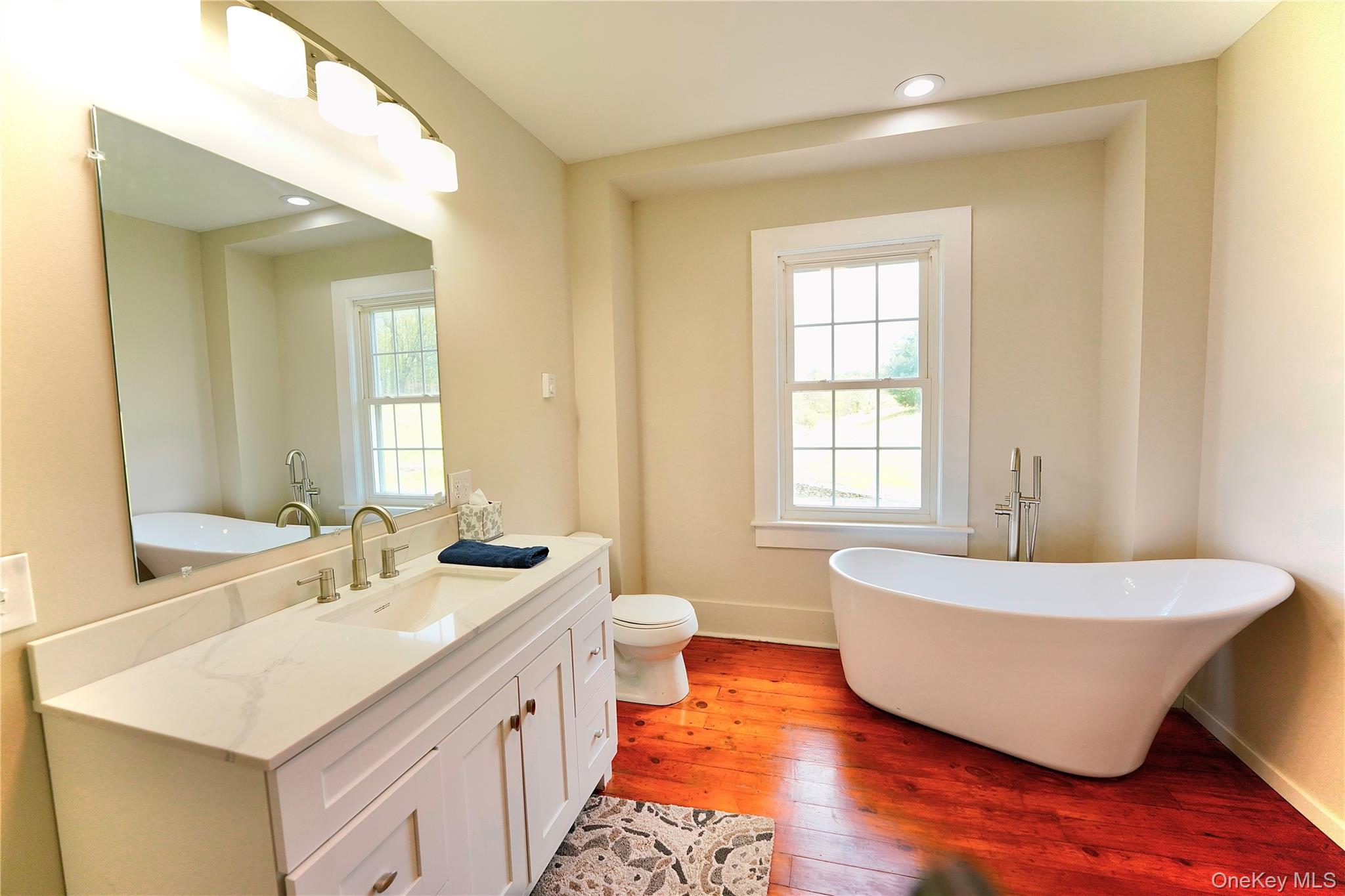 70 Royce Road Bethel, NY 12786 - Photo 37 of 48 a spacious bathroom with a double vanity sink mirror and a bathtub